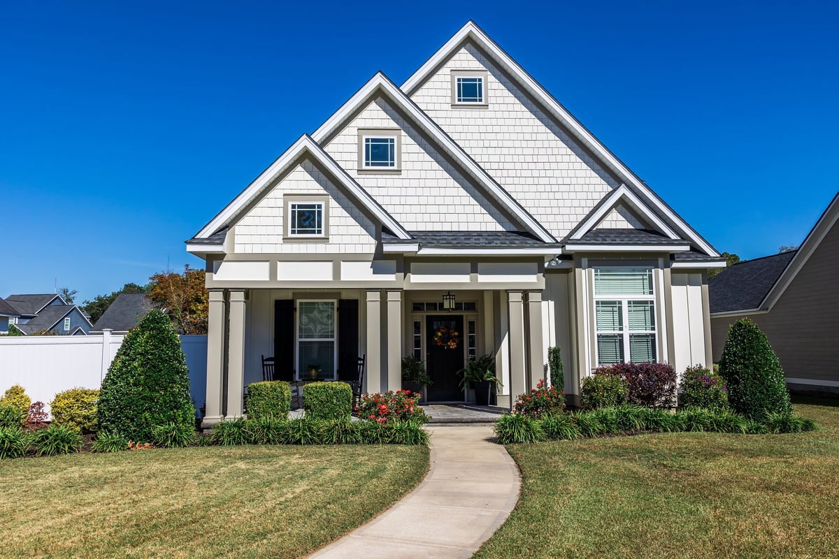 Front view of a completed craftsman-style new home with landscaping