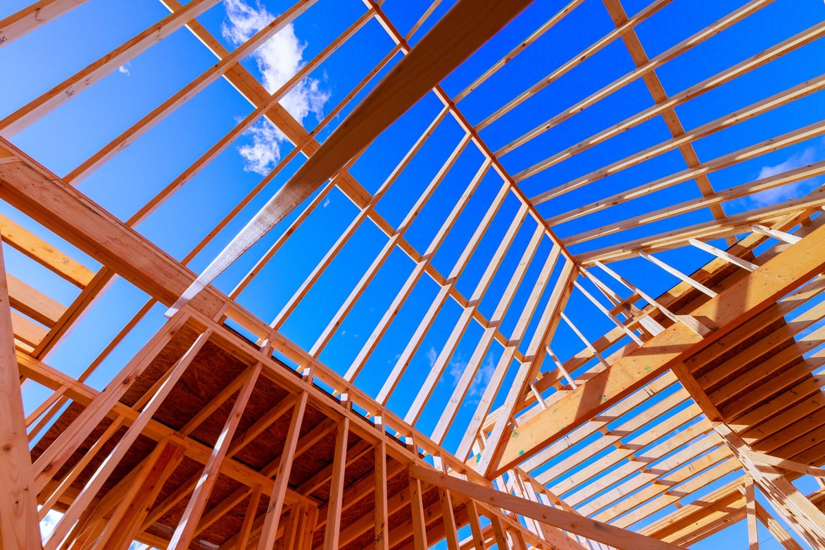 Crew framing a new home under roof trusses in North Carolina